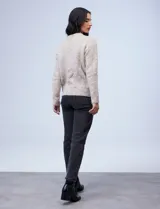 Buzo de tejido melange color beige con puntos oscuros, cuello redondo y manga larga.