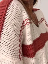 Sweater tejido a rayas horizontales color ladrillo y blanco, con cuello redondo y mangas largas.