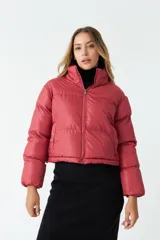 Campera puffer corta color ladrillo, con cuello alto y cierre frontal.