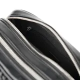 Bandolera negra de símil cuero con diseño texturizado. Tiene formato rectangular, acceso con cierre, correa regulable y herrajes plateados. Cuenta con dos compartimentos, un bolsillo interno con cierre, un bolsillo interno abierto y un bolsillo externo con botón imantado. El interior está forrado en tela de algodón y poliéster.