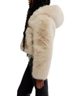 Chaqueta corta de pelo sintético color beige claro, con capucha fija y cierre frontal.