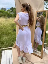 Vestido de corte vaporoso con volantes en el ruedo y mangas cortas, color violeta.