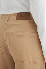 Pantalón jean color beige, de corte ancho y tiro alto.
