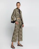 Pantalón negro con estampado dorado de motivos geométricos, corte flare y tiro alto.