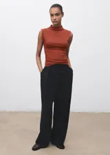 Camiseta sin mangas, ajustada al cuerpo, color terracota/óxido, con cuello perkins y fruncidos laterales.