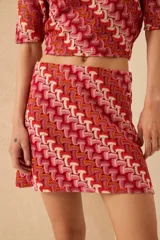 Minifalda de tejido de punto con estampado geométrico en tonos rojo, rosa, naranja y blanco.
