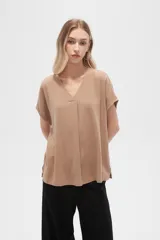 Blusa color beige de lino, holgada y con cuello en V.
