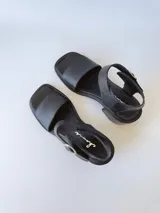 Sandalias de cuero negro con taco cuadrado de 6cm y tira ancha sobre los dedos.