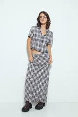 Falda larga de silueta fluida con estampado a cuadros en tonos marrones y beige. La prenda tiene una caída liviana y un calce cómodo.