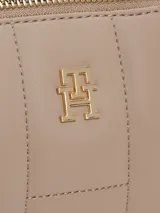 Cartera tipo clutch Tommy Hilfiger color beige con diseño acolchado, cierre de cremallera, correa de hombro y logo TH dorado en el frente.