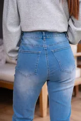 Jean de tiro alto color celeste, con cinco bolsillos, corte ajustado y cierre frontal con cremallera y botón.