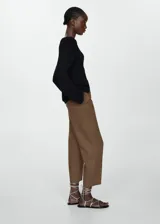 Pantalón negro de lino con diseño crop y jogger, tiro medio, cintura elástica con lazo, dos bolsillos laterales y dos bolsillos de ribete en la parte posterior.