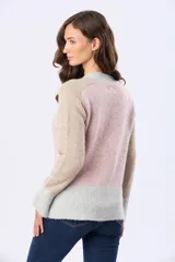 Buzo tejido de abrigo con bloques de color en rosa, beige y gris claro. Tiene cuello redondo y mangas largas.