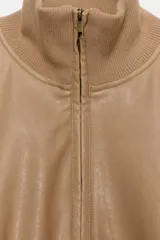 Chaqueta bomber de corte cropped confeccionada en material efecto piel color beige, con cuello subido, puños y cintura en rib elástico a tono, cierre frontal con cremallera y bolsillos laterales de vivo.