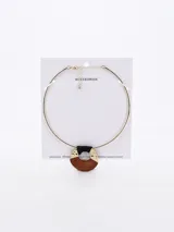 Gargantilla dorada con dije circular de madera y detalles en negro y dorado.