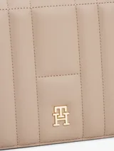 Cartera de hombro Tommy Hilfiger color beige con diseño acolchado y logo dorado en el frente. Cuenta con correa de hombro y cierre magnético.