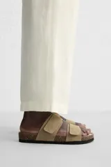 Sandalias color beige de piel con acabado serraje, doble tira con cierre adherente y plantilla anatómica.