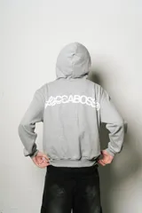 Hoodie gris con cierre, corte regular fit y estampa en el frente.