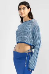 Sweater corto tejido en color azul y blanco, con detalle de cobre con logo.