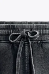 Shorts de tiro alto confeccionados en tejido con efecto lavado, cintura elástica ajustable con cordones, bolsillos laterales de vivo y tejido combinado en rib a tono.