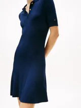 Minivestido azul marino de tejido acanalado con cuello tipo chomba y tapeta de tres botones dorados con el logo de Tommy Hilfiger grabado. Corte slim y falda evasé.