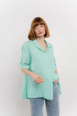 Camisa color verde agua, confeccionada en lino, de corte amplio, con cuello camisero, botones en el frente y mangas 3/4 que se pueden arremangar.