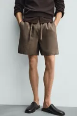 Bermuda negra de lino con calce relajado. Presenta cintura elástica ajustable con cordón, bolsillos frontales y un bolsillo trasero de plastrón.