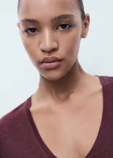 Camiseta de lino color vino tinto, con cuello en V y manga corta, de corte recto.