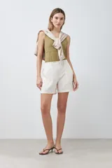Short color beige claro, de tiro alto, con bolsillos laterales y cierre frontal con botón.