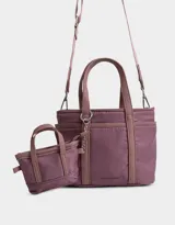 Cartera tipo tote color beige, de tela deportiva, con doble asa corta y correa larga regulable y desmontable. Tiene un bolsillo lateral con forma de pouch.