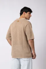 Camisa negra tejida de manga corta, con calado aireado, cuello tipo bowling y botones al tono. Diseño de corte relajado.