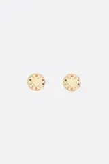 Caravanas circulares en tono dorado con un corazón central y letras de colores grabadas en el borde. Cuentan con cierre de gancho y están confeccionadas en latón con detalles esmaltados.