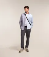 Camisa de hombre de corte clásico, confeccionada en tejido oxford con bloques de color celeste y gris. Cuenta con cuello tradicional, abotonadura frontal, mangas largas y bolsillo de parche en el pecho.