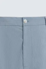 Bermuda de hombre color celeste claro, de corte regular fit, con textura arrugada y bolsillos frontales y traseros de plastrón.