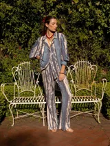 Pantalón de corte recto con cintura elástica, color beige con estampado de rayas verticales azules.