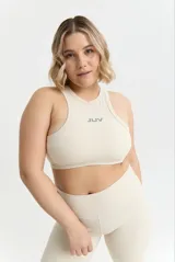 Top deportivo color crema con diseño halter, calce ajustado y almohadillas removibles.