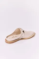 Sueco de cuero negro con detalle de apliques metálicos triangulares plateados.