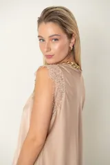 Blusa de satén de seda color beige con escote en V y hombros de encaje, de calce holgado y diseño elegante.