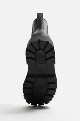 Bota Chelsea negra de cuero sintético, con elásticos laterales, tirador trasero y suela track.