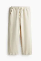 Pantalón color crema de lino y algodón, corte recto, con cintura elastizada y cordón ajustable.