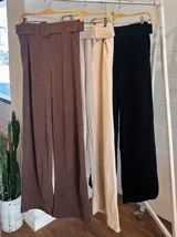 Pantalón de vestir color beige, de corte recto y tiro alto, con cinturón ancho de la misma tela y hebilla rectangular.