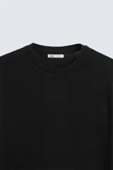 Jersey de punto color marrón oscuro, de corte relajado (relaxed fit), con cuello redondo y manga corta.