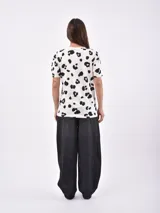 Remera blanca con estampado de manchas negras tipo animal print.