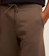 Bermuda masculina de corte slim fit, color marrón, confeccionada en algodón con felpa. Presenta cintura elástica con cordón ajustable y bolsillos laterales.