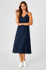 Vestido midi color rosa pálido, de corte recto y breteles finos con detalle metálico.