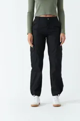 Pantalón cargo negro de tiro medio con cintura elastizada, bolsillos laterales y ajuste en los tobillos.