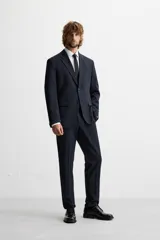 Pantalón de vestir azul marino, de corte slim fit, con bolsillos laterales y traseros de vivo con botón. Se ajusta a la cintura con cierre frontal con cremallera y botón.
