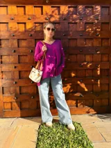 Cartera bandolera de cuero crudo con forro de tela, bolsillo frontal y bolsillo interno. Tiene correa larga regulable y manijas cortas de cuero marrón.