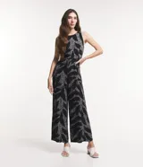 Mono largo sin mangas de viscosa twill color negro con estampado de follaje en blanco. Tiene cuello redondo, cierre con botón en la espalda y bolsillos laterales.