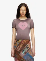 Camiseta ajustada de manga corta, color marrón grisáceo con efecto desgastado. Presenta un estampado frontal de un corazón rosa con el logo de Diesel en el centro.